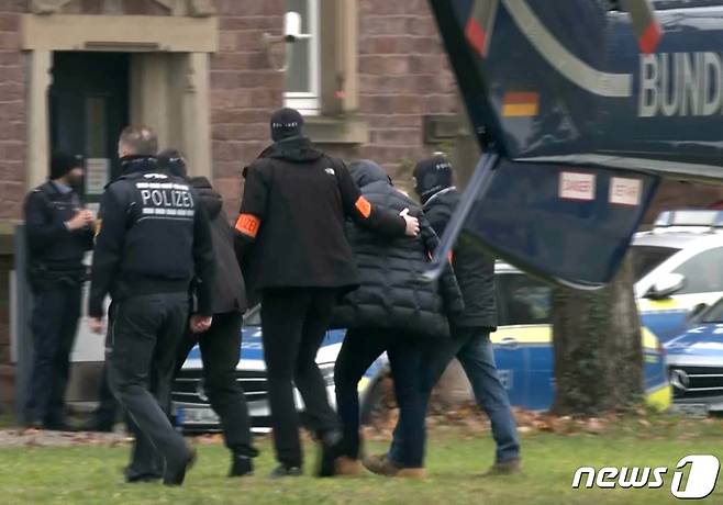 독일 경찰이 7일(현지시간) 프랑크푸르트에서 국가 전복을 모의한 혐의로 극우 단체 핵심 인물인 71세 남성 하인리히 13세를 체포해 호송하고 있다.  ⓒ 로이터=뉴스1 ⓒ News1 이유진 기자