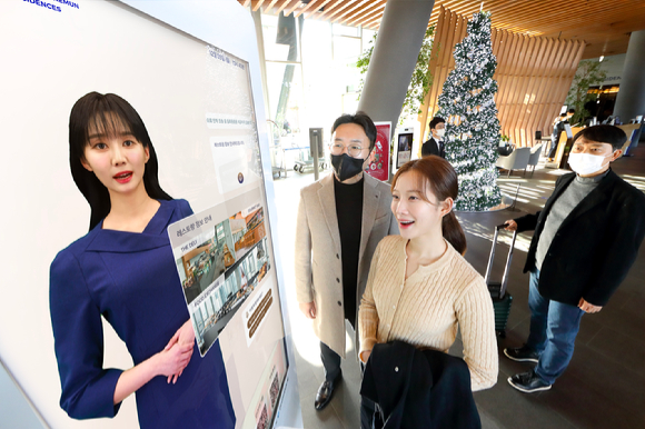 모델이 노보텔 앰배서더 서울 동대문 호텔＆레지던스 1층 로비에 설치된 'AI 컨시어지' 앞에서 호텔 서비스 안내를 받고 있다. [사진=KT]