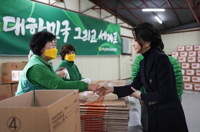 [서울=뉴시스] 윤석열 대통령 부인 김건희 여사가 8일 부산 부전동 부산진구새마을지회에서 쪽방촌 독거노인 등에 전달할 생필품 포장 봉사에 앞서 봉사자들과 인사하고 있다. (사진=대통령실 제공) 2022.12.08. photo@newsis.com *재판매 및 DB 금지