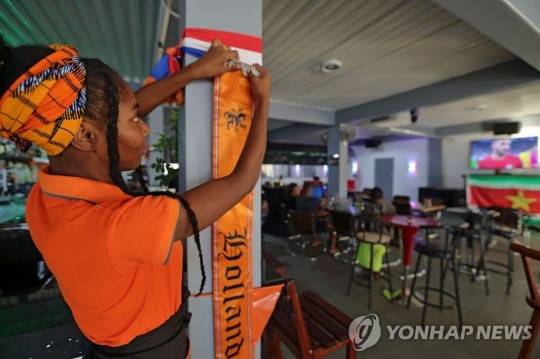 수리남의 한 식당에 네덜란드 응원 배너를 내거는 직원 [사진=연합뉴스]