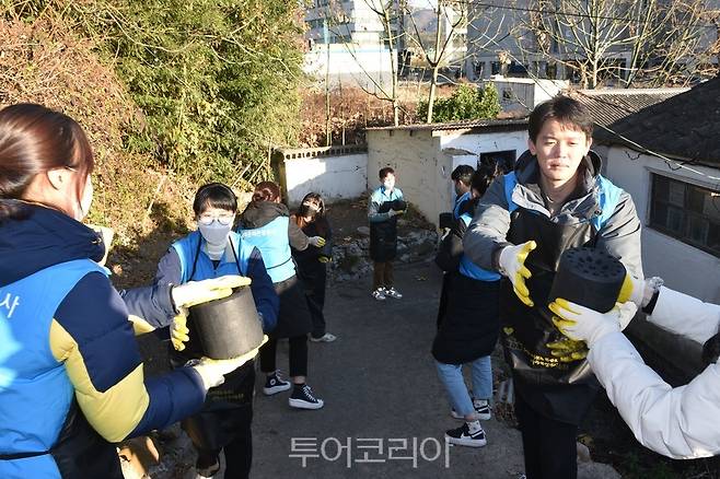 경북문화관광공사 임직원들이 연탄을 옮기고 있다