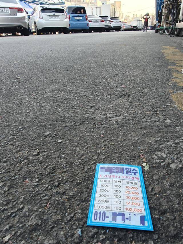 지난달 25일 서울 동대문구 청량리청과물시장 중심가에서 200m쯤 떨어진 곳에서 발견한 대부업 명함. 시장 상인들은 올해 여름까지 숱하게 보이던 명함이 가을부터 사라졌다고 전했다. 김정현 기자