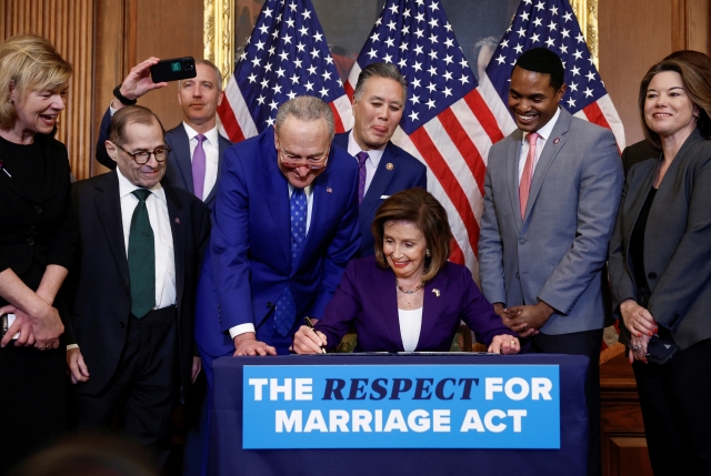 낸시 펠로시 미국 하원의장(아래 가운데)이 8일(현지시간) 워싱턴DC 국회의사당에서 동료들이 지켜보는 가운데 동성결혼과 인종간 결혼을 보장하는 '결혼존중 법안'에 서명하고 있다. 연합뉴스