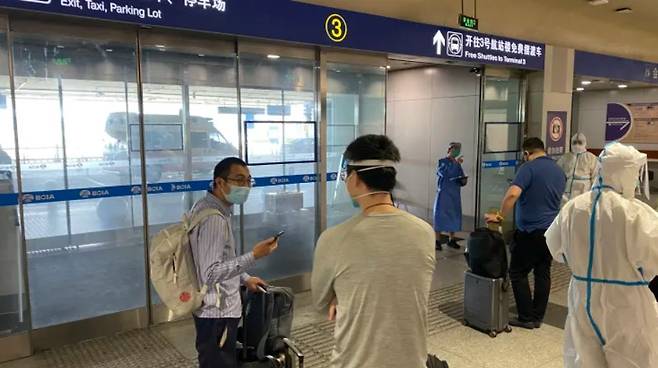중국 베이징 공항에서 지정 격리 시설로 이동하기 위해 대기 중인 해외 입국자들 /AFPBBNews=뉴스1