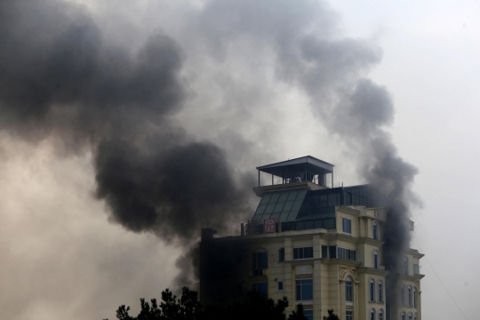 12일(현지시간) 아프가니스탄 수도 카불의 한 호텔에서 무장괴한의 공격이 발생해 호텔 주변에 검은 연기가 피어오르고 있다. 해당 호텔은 중국인 등 주로 외국인들이 많이 이용하는 곳으로 알려졌다. EPA·연합뉴스
