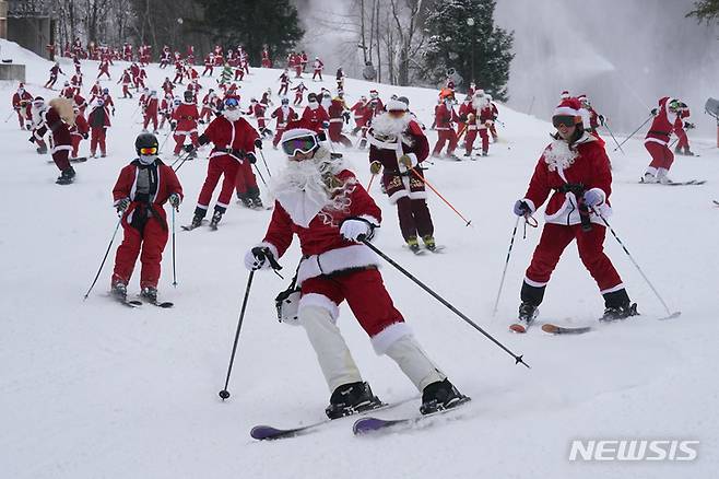 [뉴리=AP/뉴시스] 11일(현지시간) 미국 메인주 뉴리의 선데이 리버 스키 리조트에서 산타클로스 복장을 한 스키어들이 스키를 타고 있다. 2022.12.12.