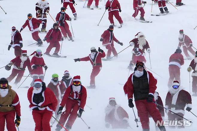 [뉴리=AP/뉴시스] 11일(현지시간) 미국 메인주 뉴리의 선데이 리버 스키 리조트에서 산타클로스 복장을 한 스키어들이 스키를 타고 있다. 2022.12.12.