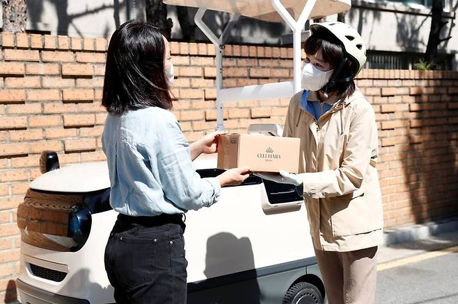 hy 프레시 매니저가 배송서비스 제휴사의 화장품 제품을 고객에게 직접 전달하고 있다. <사진제공=hy>