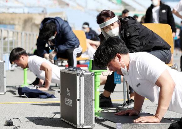 ‘1개라도 더’ - 30일 오전 인천시 미추홀구 문학경기장에서 열린 인천경찰청 경찰관 채용 체력검정에서 응시자들이 팔굽혀펴기 시험을 치르고 있다. 2021.3.30 연합뉴스