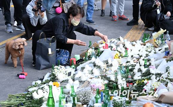 지난 10월31일 오후 서울 용산구 지하철 6호선 이태원역 1번 출구 앞에 마련된 '핼러윈 인파' 압사 사고 희생자 추모 공간에서 시민이 추모하고 있다. [사진=김성진 기자]