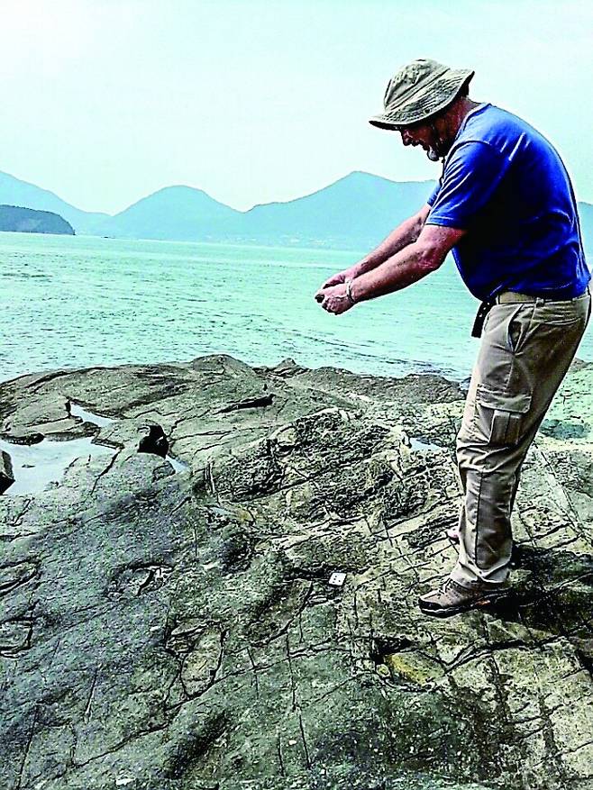경남 한 섬의 화석산지에서 발견된 두발로 걸었던 원시 악어류의 보행렬을 사진 찍고 있다. 마틴 로클리 미국 콜로라도대 명예교수