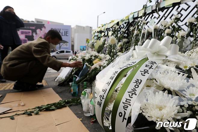 1일 오전 서울 용산구 이태원역 1번 출구에 마련된 이태원 핼러윈 압사 참사 추모공간을 찾은 추모객이 헌화를 하고 있다. 2022.11.1/뉴스1 ⓒ News1 이승배 기자