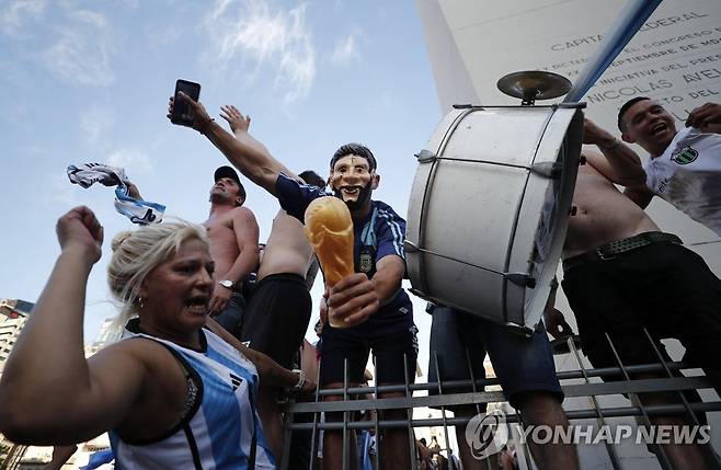 크로아티아전을 지켜보기 위해 수도 부에노스아이레스 광장에 모여 환호했던 아르헨티나 국민. 월드컵 트로피 모형을 들고 있다.  [로이터 연합뉴스 자료사진. 재판매 및 DB 금지]