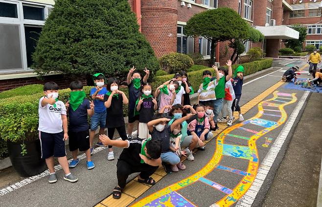 지난 여름 바닥그림을 완성한 어린이들이 그림 앞에서 기념촬영을 하고 있다.(사진=경기도교육청 제공)