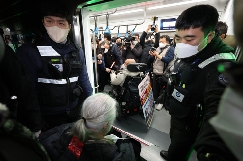 전국장애인차별철폐연대(전장연) 회원들이 지난 13일 오전 서울 용산구 4호선 삼각지역에서 출근길 지하철 탑승 시위를 하고 있다. 연합뉴스