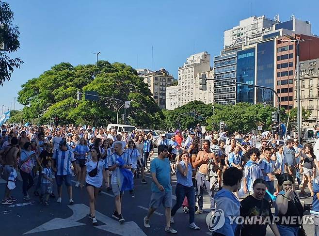 오벨리스크로 행진하는 아르헨티나 부에노스아이레스 시민들 (부에노스아이레스=연합뉴스) 김선정 통신원 = 18일(현지시간) 아르헨티나가 카타르 월드컵에서 우승하자 '7월9일대로'에서 오벨리스크로 행진하는 시민들이 응원가를 부르고 있다. 2022.12.19 sunniek8@yna.co.kr