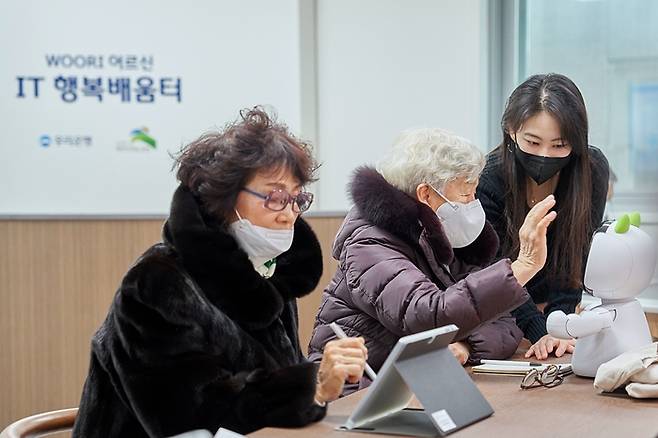 서울 은평구 역촌노인복지관 내에 있는 ‘우리 어르신 IT 행복배움터’ 에서 지난 19일 지역 주민들이 디지털 기기 사용법을 배우고 있다.  우리은행 제공