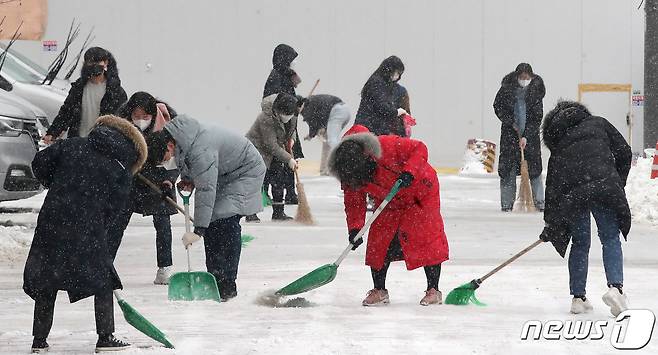 수도권에 대설특보가 발효된 21일 오전 서울 강남구 강남역 인근에서 사랑의 복지관 직원들이 눈을 치우고 있다. 2022.12.21/뉴스1 ⓒ News1 임세영 기자