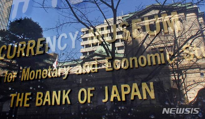 FILE - In this Feb. 15, 2011 photo, the Bank of Japan building is reflected on the glass covering the plate of its adjunct museum in Tokyo. Japan’s central bank on Monday, April 27, 2020, announced it is making it easier for cash-strapped companies to get funding in response to the growing economic damage from the coronavirus pandemic. (AP Photo/Shizuo Kambayashi, File)