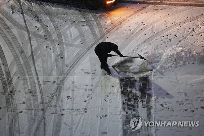 누군가의 새벽이 있기에 (서울=연합뉴스) 박동주 기자 = 서울 전역에 대설주의보가 발효된 21일 오전 서울 시내 한 빌딩에서 관계자가 눈을 치우고 있다. 2022.12.21 pdj6635@yna.co.kr