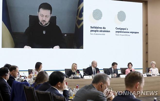 우크라 재건 국제회의에 화상으로 참여한 젤렌스키 대통령 (파리 AFP=연합뉴스) 볼로디미르 젤렌스키 우크라이나 대통령이 지난 13일(현지시간) 파리의 외무부 청사에서 열린 우크라이나 재건을 위한 회의에 화상으로 참석해 발언하고 있다. 사진 왼쪽부터 안나레나 배어복 독일 외교부 장관, 젤렌스키 대통령의 부인 올레나 젤렌스카 여사, 데니스 슈미갈 우크라이나 총리, 에마뉘엘 마크롱 프랑스 대통령, 카트린 콜로나 프랑스 외교부 장관, 우르줄라 폰데어라이엔 유럽연합(EU) 집행위원장. 2022.12.13 alo95@yna.co.kr