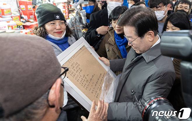 이재명 더불어민주당 대표가 22일 오전 경북 안동시 옥야동 안동중앙신시장에서 한 지지자가 건네준 선물을 바라보고 있다. 2022.12.22/뉴스1 ⓒ News1 이재명 기자