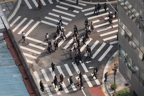 글로벌 경기 하락 이후 대기업이 간접적으로 일자리를 줄이는 '조용한 해고'에 나서고 있다. 희망퇴직이나 정리해고 요건이 까다로운 상황에서 간접적 구조조정이라는 해석이 나온다. 사진은 서울 중구의 사무실 밀집 지역의 횡단보도를 건너가는 시민들. 연합뉴스