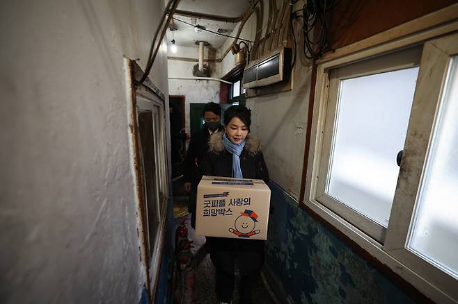 김건희 여사가 22일 서울 남대문 쪽방촌에서 열린 ‘이웃과 함께하는 2022 찾아가는 성탄절, 희망박스 나눔행사’에서 쪽방촌 주민들에게 식료품 등이 담긴 ‘희망박스’를 전달하고 있다. [제공 : 대통령실]