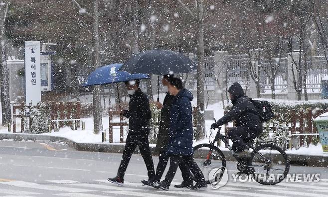 대설주의보 내려진 대전 (대전=연합뉴스) 강수환 기자 = 대전에 대설주의보가 내려진 22일 오전 둔산동에서 시민이 흩날리는 눈을 맞으며 걸어가고 있다. 2022년 12월 22일 swan@yna.co.kr