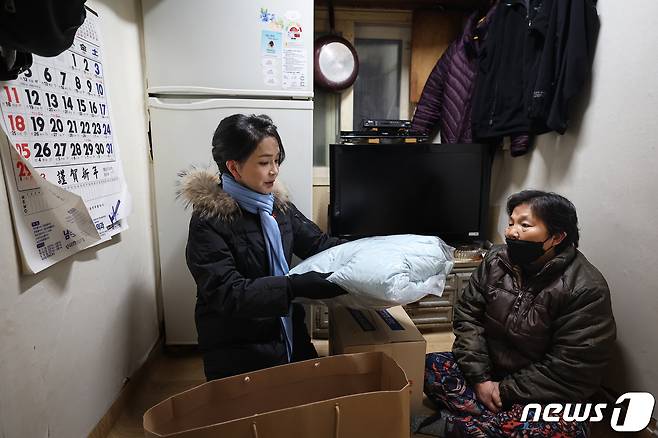 윤석열 대통령 부인 김건희 여사가 22일 2022 찾아가는 성탄절 희망박스 나눔행사를 위해 서울 용산구 남대문쪽방촌을 찾아 어르신에게 겨울 점퍼를 선물하고 있다. (대통령실 제공) 2022.12.22/뉴스1 ⓒ News1 안은나 기자