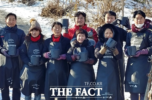 24일 연탄배달에 나선 대전 대덕구의원들이 마지막 연탄 1장씩 들고 기념촬영하고 있다. 이들은 기념촬영을 마친 뒤 들었던 연탄을 직접 날랐다. / 대전=라안일 기자