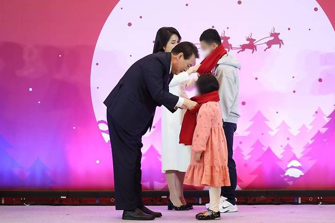 [서울=뉴시스] 윤석열 대통령과 부인 김건희 여사가 23일 청와대 영빈관에서 열린 보호아동·자립준비청년과 함께하는 크리스마스 행사에서 아이들에게 목도리를 매주고 있다. (사진=대통령실 제공) 2022.12.23. *재판매 및 DB 금지