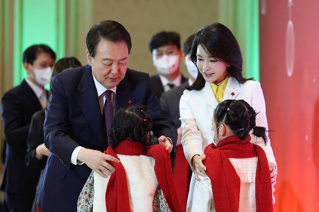 윤석열 대통령과 김건희 여사가 23일 청와대 영빈관에서 열린 보호아동·자립준비청년과 함께하는 크리스마스 행사에서 아이들에게 목도리를 걸어주고 있다. 연합뉴스