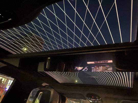 BMW 뉴 7시리즈. 야간 주행 중 선루프를 열면 곡선과 아가일 체크 패턴이 빛난다. 선루프 가운데는 시어터 스크린이 접힌 모습. 장우진 기자