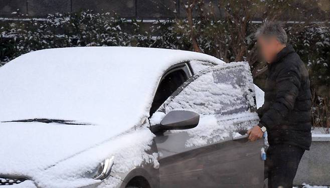 [전주=뉴시스] 김얼 기자 = 쌀쌀한 겨울 날씨가 이어지고 있는 22일 전북 전주시 완산구 중앙동에서 한 시민이 눈이 쌓인 차량에 탑승하고 있다. 2022.12.22.
