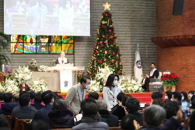 [서울=뉴시스] 윤석열 대통령과 부인 김건희 여사가 성탄절인 25일 서울 성북구 영암교회에서 열린 성탄 예배에서 신자들에게 인사하고 있다. 대통령실에 따르면 영암교회는 윤 대통령이 초등학교 1학년부터 중학교 1학년까지 다녔던 교회다. (사진=대통령실 제공) 2022.12.25. photo@newsis.com *재판매 및 DB 금지