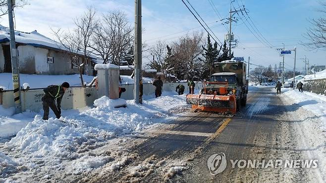 깨끗해진 도로 (부안=연합뉴스) 24일 전북 부안군에서 육군 35사단 장병들이 주민과 함께 제설 작업을 하고 있다. 2022.12.24 [육군 35사단 제공. 재판매 및 DB금지] jaya@yna.co.kr