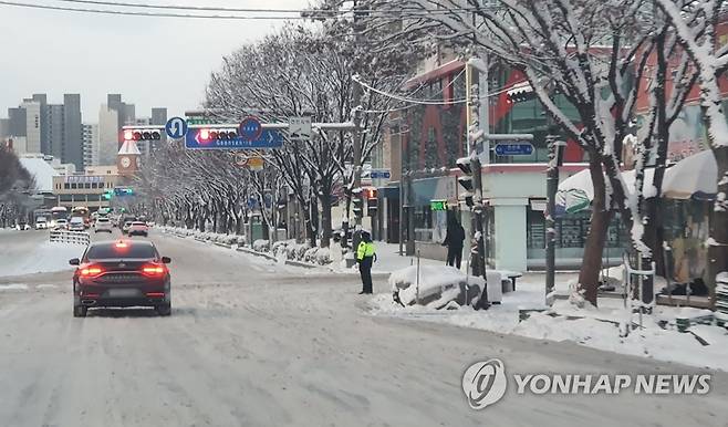 빙판길로 변한 전주 시내 도로 (전주=연합뉴스) 김동철 기자 = 23일 대설특보가 내려진 전북 전주시 덕진구 모래내시장 일대에서 차량이 서행하고 있다. 2022.12.23 sollenso@yna.co.kr