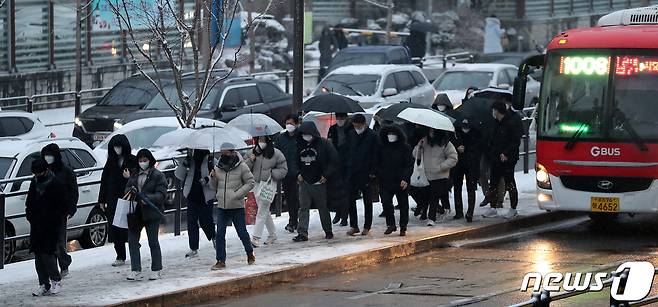 서울을 비롯해 중부지방에 대설특보가 발효된 21일 오전 서울 동작구 사당역 인근 버스정류소에서 시민들이 전철역으로 향하고 있다. 2022.12.21/뉴스1 ⓒ News1 김진환 기자