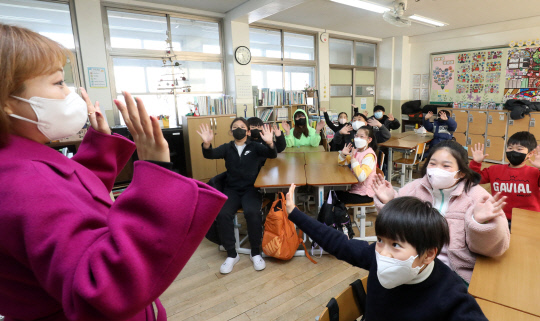 27일 대전 중구 서대전초등학교에서 겨울 방학을 맞은 4학년 학생들이 선생님과 인사를 나누고 있다.