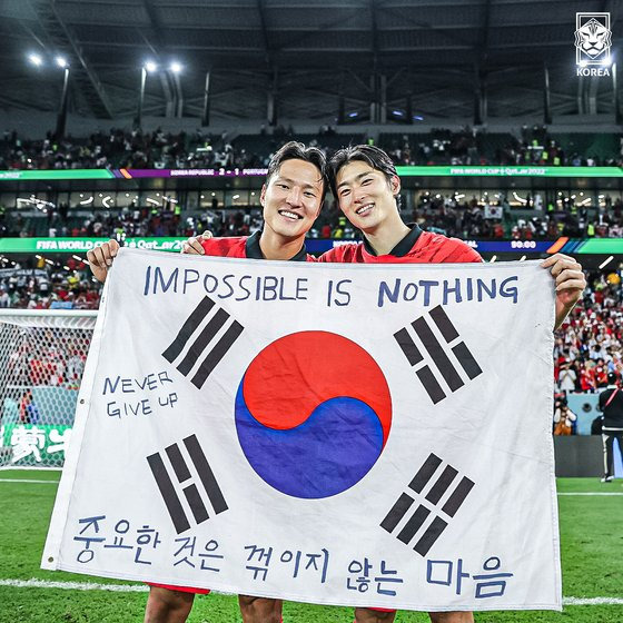 한국 축구 국가대표팀 권경원(왼쪽), 조규성이 12월 3일 2022 카타르월드컵 포르투갈전에서 승리한 후 ‘중요한 것은 꺾이지 않는 마음’ 문구가 적힌 태극기를 들고 포즈를 취하고 있다. 대한축구협회 제공