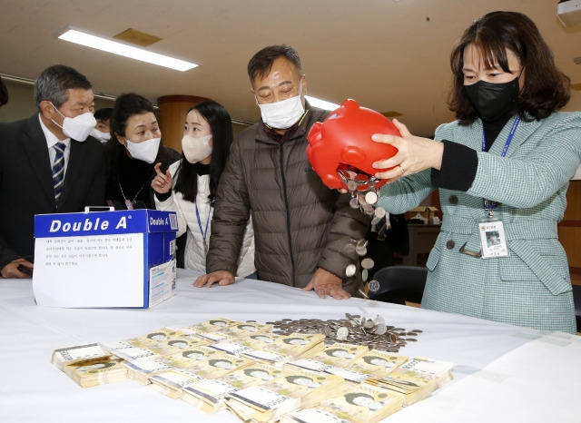 전주시 노송동주민센터 직원들이 27일 ‘얼굴 없는 천사’가 놓고 간 상자를 열고 성금을 확인하고 있다. 전주시 제공.