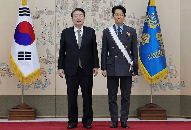 윤석열 대통령이 27일 서울 용산 대통령실 청사에서 드라마 '오징어 게임'으로 미국 에미상 남우주연상을 받은 배우 이정재 씨에게 금관문화훈장을 수여한 후 기념촬영을 하고 있다.  <이승환 기자>