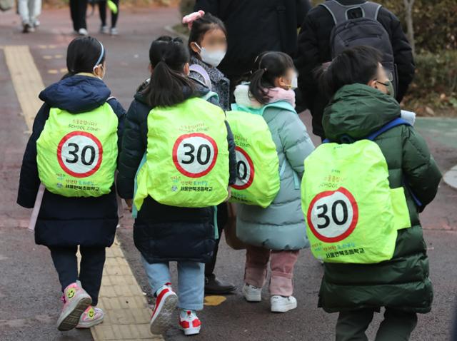 13일 서울 강남구 언북초 학생들이 '스쿨존입니다!'라고 적힌 형광색 보호덮개를 씌운 가방을 메고 등교하고 있다. 뉴스1