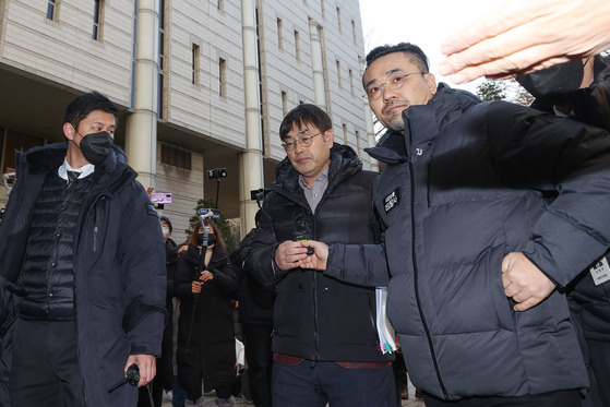 Kang Jin-gu, center, at the Seoul Central District Court in Seocho-dong, southern Seoul, on Thursday attends a hearing for an arrest warrant requested by prosecutors related to accusations of trespassing at Justice Minister Han Dong-hoon's apartment. Tamsa TV says Han is seeking to silence the press. Kang and Tamsa TV have been ordered by the court to keep a distance of 100 meters from the Justice Minister. [YONHAP]