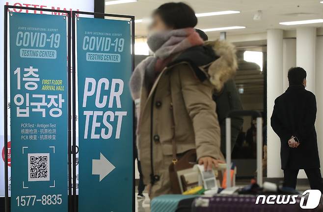 사진은 29일 김포공항 국제선 입국장 내 PCR 검사장 안내판 앞을 지나는 해외 입국자 모습. 202212.29/뉴스1 ⓒ News1 임세영 기자
