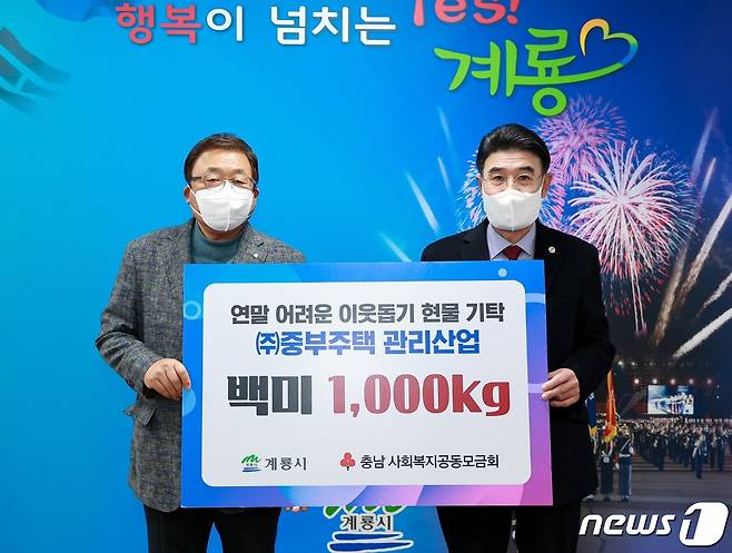 이병기 중부주택관리산업 회장(왼쪽)이 계룡시청을 방문해 이응우 시장에게 백미 1000kg를 기탁한 후 기념촬영을 하고 있다. (계룡시 제공) /뉴스1