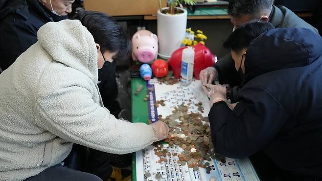 서울 중구청 환경공무관들이 연말을 맞아 돼지저금통을 개봉했다. 이들은 2014년부터 청소하면서 주운 동전을 모아 불우이웃에게 기부했다. [제공 =  서울 중구청]