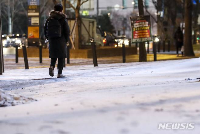 [서울=뉴시스] 정병혁 기자 = 28일 오전 서울 종로구 광화문네거리 인근에서 시민들이 눈을 밟으며 이동하고 있다. 2022.12.28. jhope@newsis.com