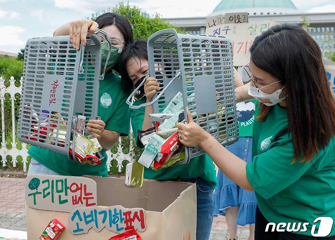 소비자기후행동 회원들이 16일 서울 여의도 국회의사당 앞에서 열린 소비기한표시제 도입 촉구 기자회견에서 퍼포먼스를 하고 있다. 참가자들은 소비기한표시제가 소비자에게 식품 폐기 시점에 대한 정확한 정보를 전달하고 식품 낭비를 줄여 환경보호를 할 수 있다며 제도 도입을 촉구했다. 2021.6.16/뉴스1 ⓒ News1 안은나 기자